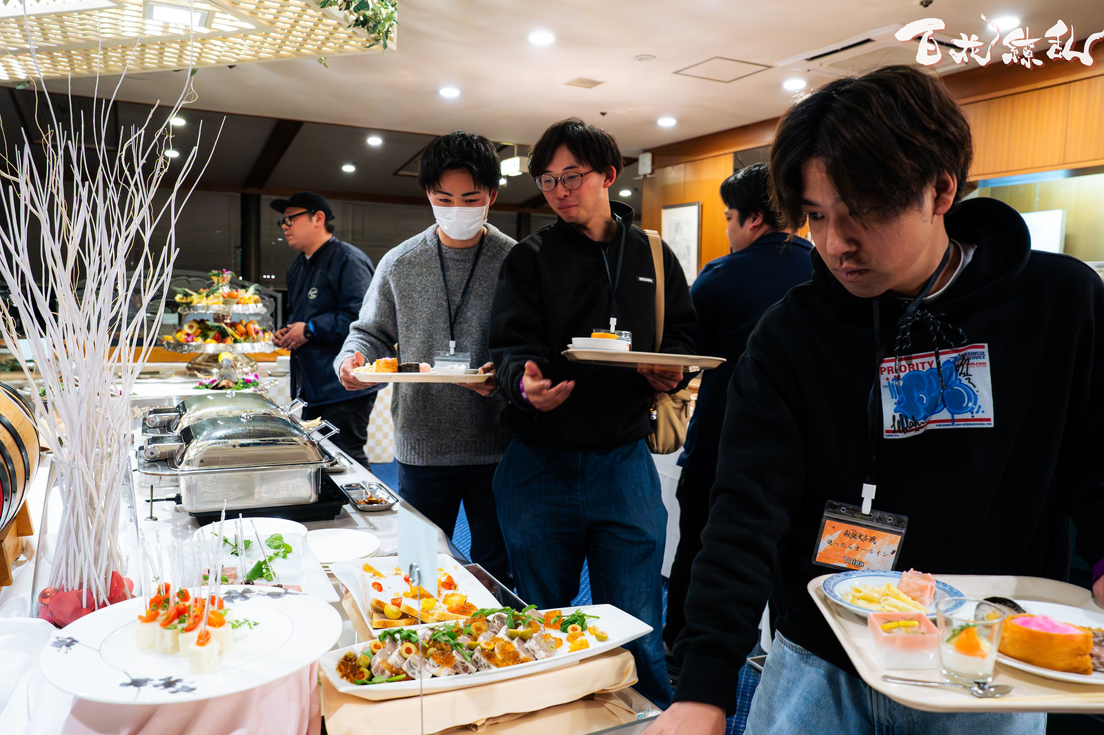 料理を選びながらビュッフェを楽しむ百花繚乱の参加者たち
